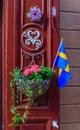 Ornate red door decorated with a Swedish flag and a flower pot i Royalty Free Stock Photo