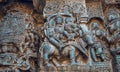 Ornate relief of Siva and Parvathi sitting on bull and money other stories in stone. 12th century temple in India.