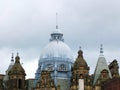 The ornate roof dome and towers of leeds city market in west yorkshire against a grey cloudy sky