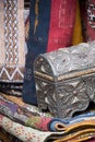 Ornate silver trinket box with colorful textiles on sale in a Moroccan Market