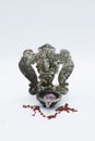 An ornate statue of ganesh / ganesha statue holding a rose quartz, surrounded by red chakra stones on an isolated white background Royalty Free Stock Photo