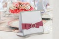 Ornate table name card with pink ribbon