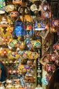 Ornate and vibrant collection of Turkish lamps hangs from the window of an authentic market