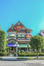 Ornate Victorian House trimmed with gingerbread and bright colors with turret and gargoyle on top of dormer