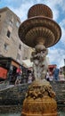 Ornate water fountain in a city large group of people in the background, in Corsica, France