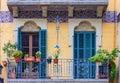 Ornate windows with blue wooden shutters, carvings and mosaic in