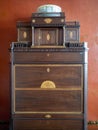 Ornate wooden antique cabinet with golden inlays on display