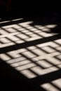 Ornate wooden screen casts interesting shadow on stone floor.