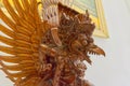 Ornate wooden statue on a bird shaped table. object photography style