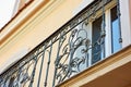 Ornate wrought iron balcony railing with intricate designs, beige wall Royalty Free Stock Photo