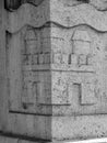 Corner of building is decorated with carved stone image of ancient fortress. Decorative stone architectural elements