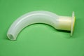 Oropharyngeal Airway tube with connector isolated on green background Royalty Free Stock Photo