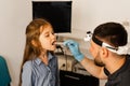 Oropharyngoscopy procedure. Otolaryngologist examines child throat with spatula. Consultation with laryngologist.