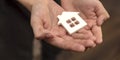 Orphanage, children in the orphanage. The child is holding a small house-shaped figurine, close-up. Adoption concept