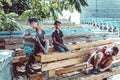 Orphaned children sit in an abandoned park on old benches