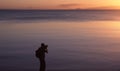 Photographer in silhouette taking photographs at sunset on the beach of Orpheus Island