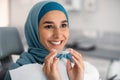 Orthodontics Concept. Smiling Muslim Woman In Hijab Holding Invisalign Or Invisible Braces