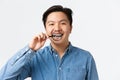 Orthodontics, dental care and stomatology concept. Close-up of young asian guy showing his teeth braces with magnifying
