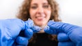 Orthodontist doctor in gloves holding invisible braces show to woman in clinic Royalty Free Stock Photo