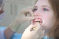 Orthodontist covering special gel on woman teeth in dentistry using brush. Royalty Free Stock Photo