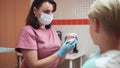 Orthodontist with teen boy and aligners in hospital office