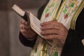 Orthodox baptism in the church priest reading from book with text for baptism closeup