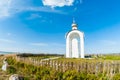 Orthodox chapel white with a transparent facade on the background of the panorama of the sea and blue sky in a field Royalty Free Stock Photo