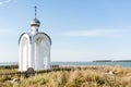 Orthodox chapel white with a transparent facade on the background of the panorama of the sea and blue sky in a field Royalty Free Stock Photo