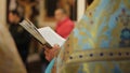 Orthodox Church clergyman reading psalm book, conducting festive service, prayer