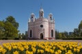 Orthodox Church of the Nativity of St. John against the sky in St. Petersburg, flowerbed with yellow tulips