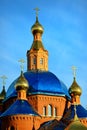 The Orthodox Church is of red brick with Golden domes against the blue sky at sunset. Russia, Belgorod. Royalty Free Stock Photo