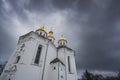 An Orthodox church with white facades and golden domes against a cloudy cloudy sky and clouds Royalty Free Stock Photo