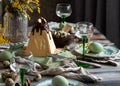 Orthodox Easter table setting with caramel easter cottage cheese cake on wooden light green board on grey wooden table