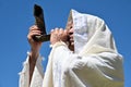 Orthodox Jewish man blow Shofar against clear blue sky