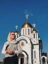 Orthodox lifestyle woman in a scarf stands on the background of the Orthodox Church.