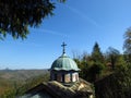 Orthodox monastery dome roof with a metal cross on the top in mountains. Century old monastery church surrounded by trees. Royalty Free Stock Photo