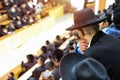 Orthodox Hasidim listen to their rabbi during mass prayer in In a synagogue.