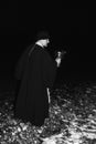 An Orthodox priest blesses the water in the river the night of the feast of the Epiphany, a black and white photo