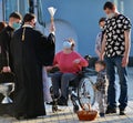 An Orthodox priest blesses a woman sitting on a wheelchair on the eve of Orthodox Easter
