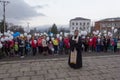 Orthodox priest and people with white balloons on the day of mourning for those killed in a fire in Kemerovo