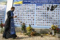 Orthodox priest prays near Memory Wall of Fallen Defenders of Ukraine in war in Eastern Ukraine 2014-2020. Kyiv, Ukraine