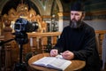 . An Orthodox priest is recording a video for his blog. Preaching during a pandemic