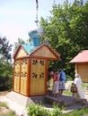 Orthodox women pilgrims collect water in a well with consecrated water.