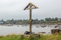 Orthodox Wooden Cross and Church on Background at Low Tide
