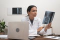 orthopedic doctor reviews patient X-ray films scans while working with laptop, online medicine. Royalty Free Stock Photo