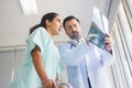 orthopedic surgeon examines an x-ray film of a patient's knee joint and recommend symptoms to patients