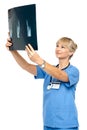 Orthopedic surgeon holding up x-ray to analyze