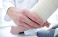 Orthopedist applying bandage onto patient`s hand in clinic Royalty Free Stock Photo