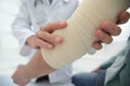 Orthopedist applying bandage onto patient`s hand in clinic Royalty Free Stock Photo