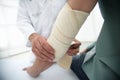 Orthopedist applying bandage onto patient`s hand in clinic Royalty Free Stock Photo